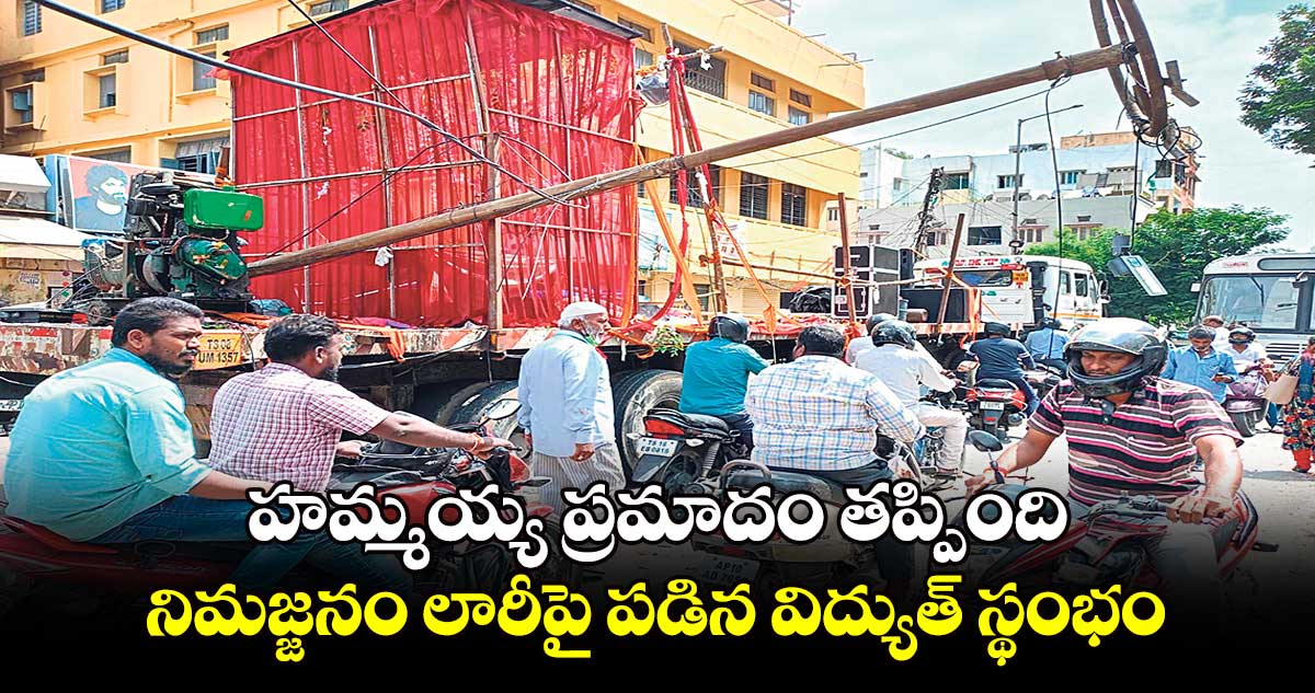 హమ్మయ్య ప్రమాదం తప్పింది: నిమజ్జనం లారీపై పడిన విద్యుత్ స్థంభం